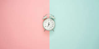 Wecker vor blau rosa Hintergrund