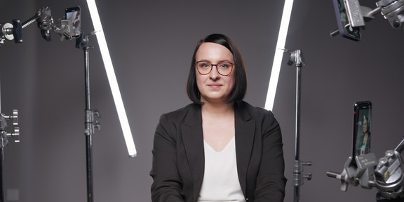 Dr. Julia Wustmann, sitzend, in einem Filmstudio